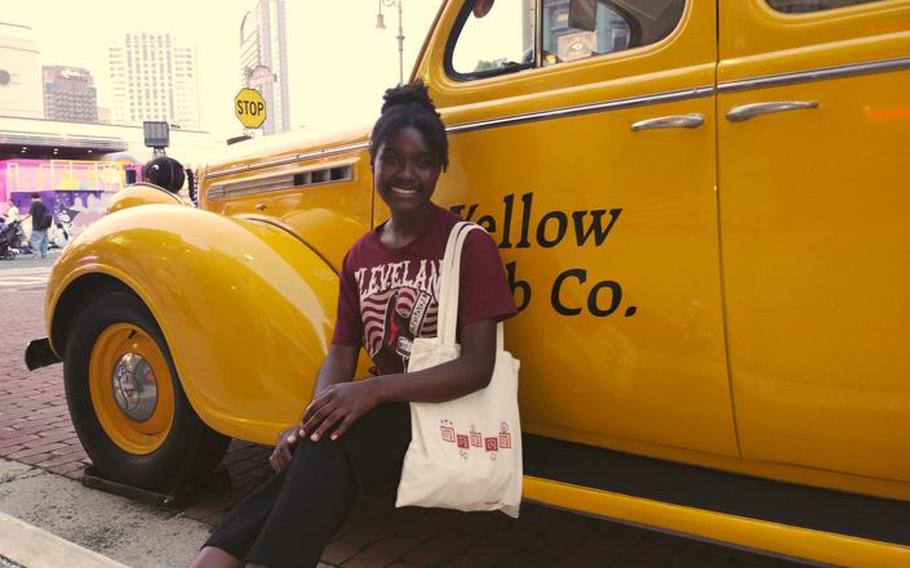 Maame Akua Sarpong in front of a taxi